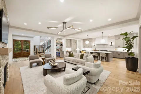 a living room with furniture kitchen view and a large window