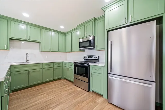 a kitchen with stainless steel appliances granite countertop a refrigerator sink and microwave