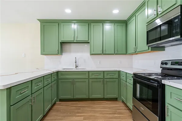 a kitchen with stainless steel appliances granite countertop a sink and a microwave