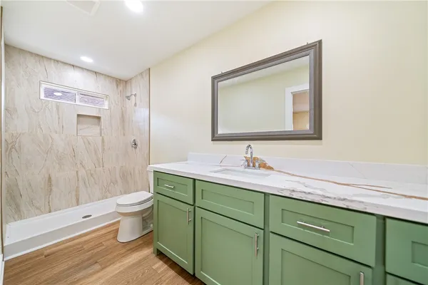 a bathroom with a toilet sink double vanity and mirror