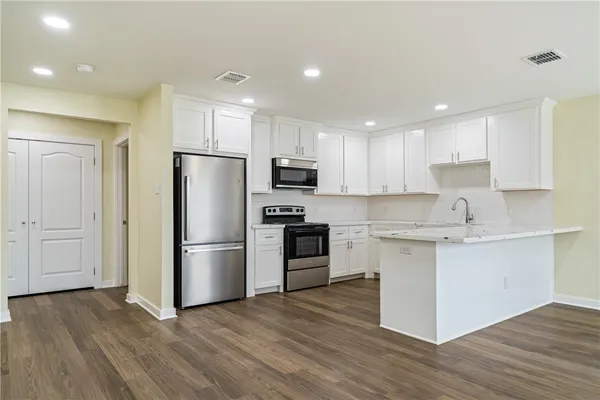a kitchen with a refrigerator cabinets and wooden floor