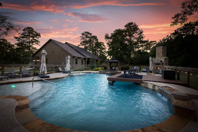 a swimming pool view with a seating space and a garden view