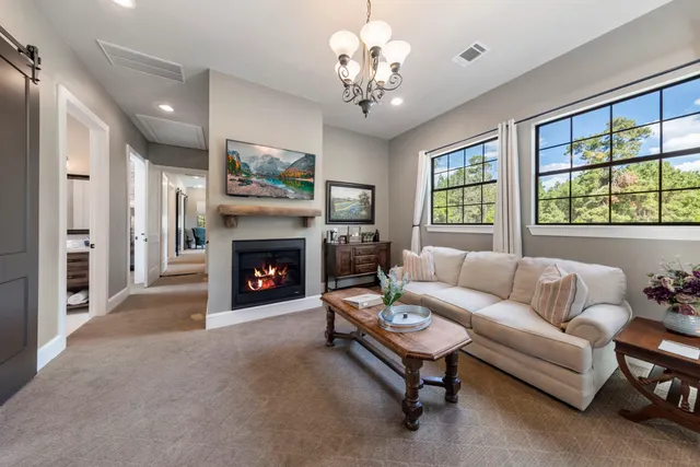 a living room with furniture a fireplace and a large window