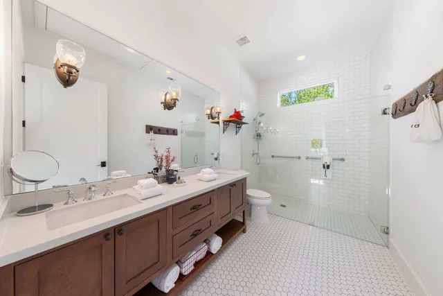 a bathroom with a double vanity sink mirror and shower