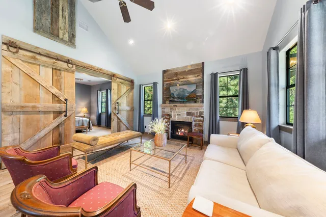 a living room with furniture a fireplace and a floor to ceiling window
