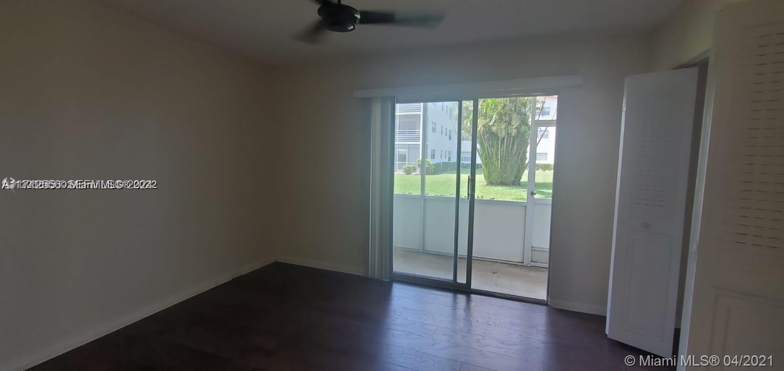 385 Fanshaw, Unit J Boca Raton, FL 33434 - Photo 6 of 7 a view of an empty room with wooden floor and a window