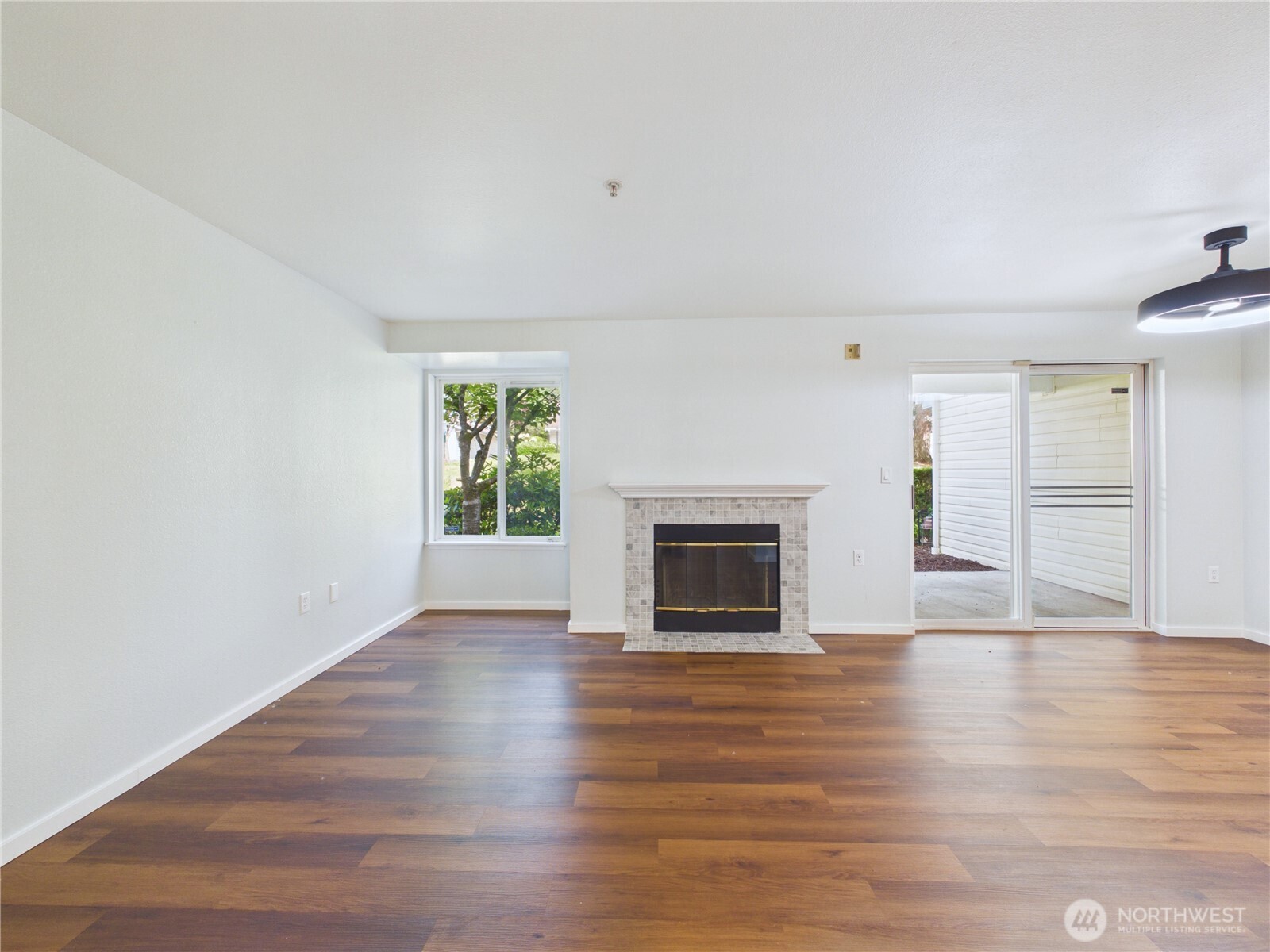 11002 Southeast Petrovitsky Road, Unit I102 Renton, WA 98055 - Photo 3 of 24 a view of empty room with wooden floor and fireplace