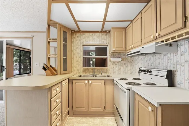 a kitchen with stainless steel appliances granite countertop a sink and cabinets with wooden floor