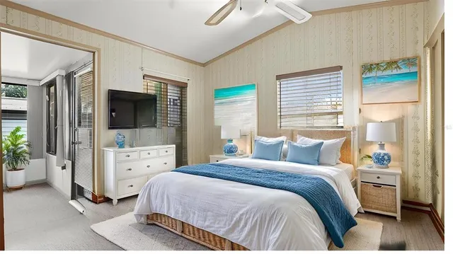 a bedroom with a bed and large windows