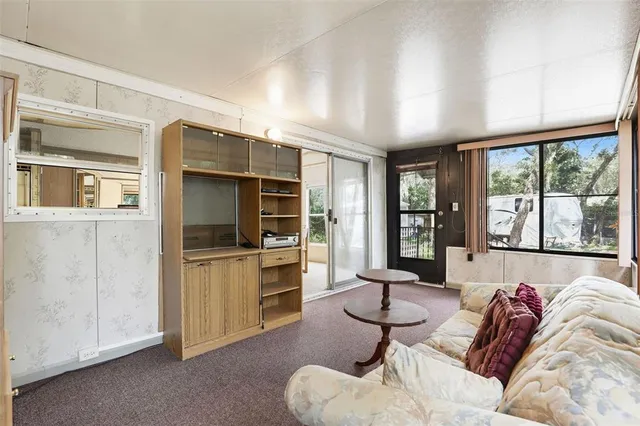 a living room with furniture large window and flat screen tv