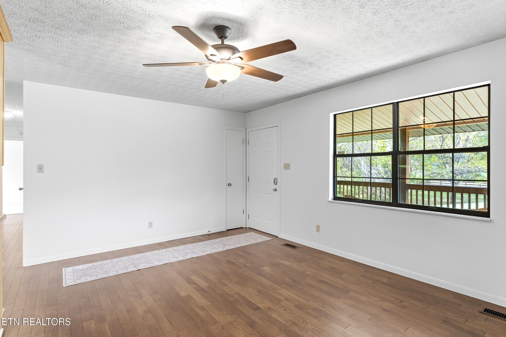 1835 Wilson Road Lenoir City, TN 37772 - Photo 7 of 57 an empty room with wooden floor fan and windows