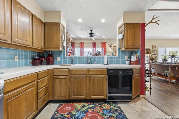 a kitchen with stainless steel appliances granite countertop a sink stove and cabinets