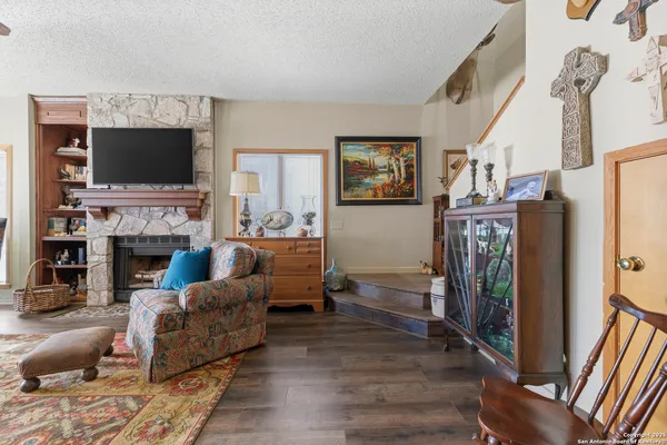 a living room with furniture a flat screen tv and a fireplace