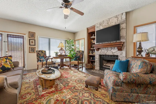 a living room with furniture a flat screen tv and a fireplace