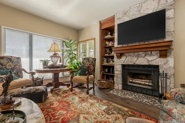a living room with furniture a flat screen tv and a fireplace