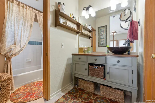 a bathroom with a sink and a mirror with bathtub