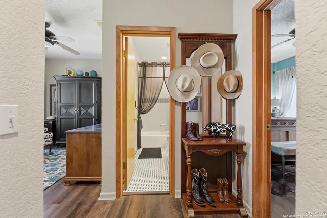 a view of a hallway with wooden floor and a kitchen view
