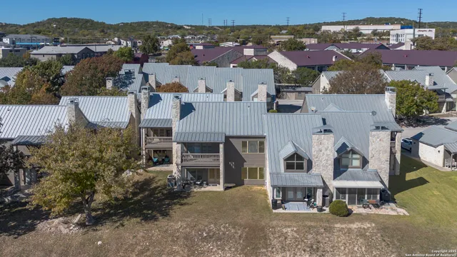 an aerial view of a house with yard and patio