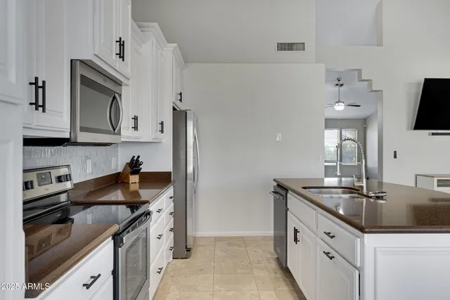a kitchen with granite countertop a sink stainless steel appliances and cabinets