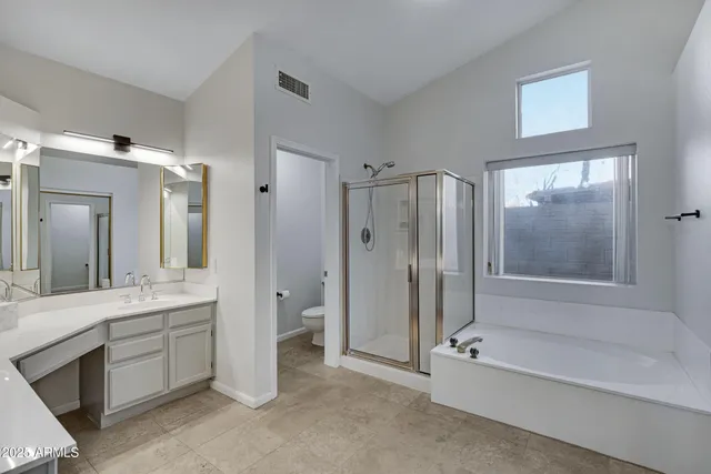a spacious bathroom with a tub sink shower and mirror