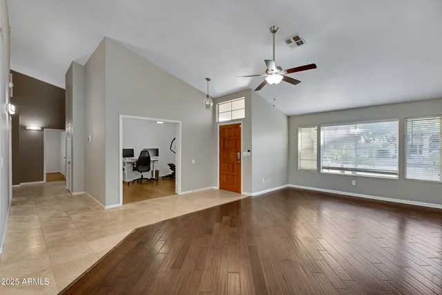 a view of a livingroom with wooden floor and a ceiling fan