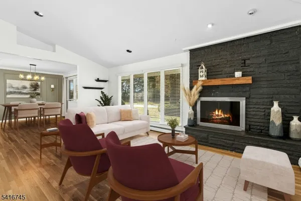 a outdoor living space with furniture a fireplace and a large window