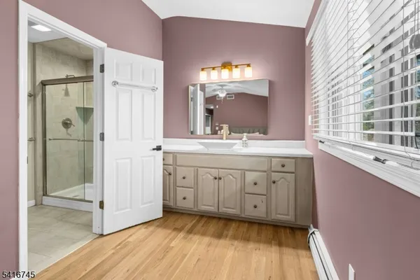 a spacious bathroom with a double vanity sink a mirror and a bathtub