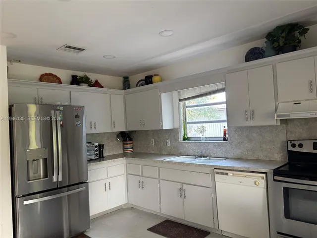 a kitchen with a refrigerator and a stove
