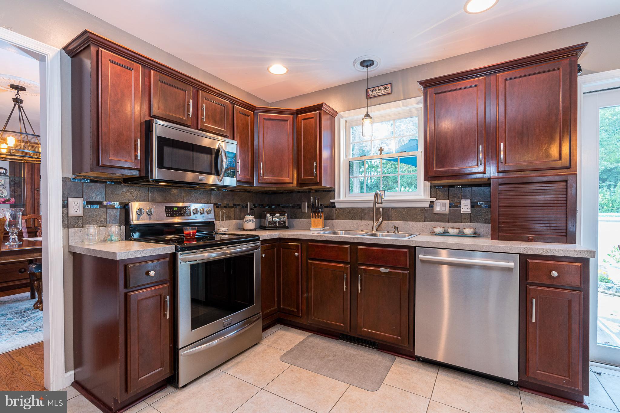 802 Augusta Drive Lititz, PA 17543 - Photo 14 of 47 a kitchen with stainless steel appliances granite countertop wooden cabinets a stove a sink and a window