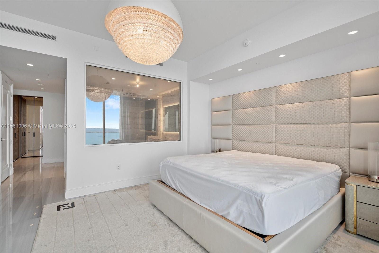 17901 Collins Avenue, Unit 902 Sunny Isles Beach, FL 33160 - Photo 25 of 47 a bedroom with a large bed and a chandelier