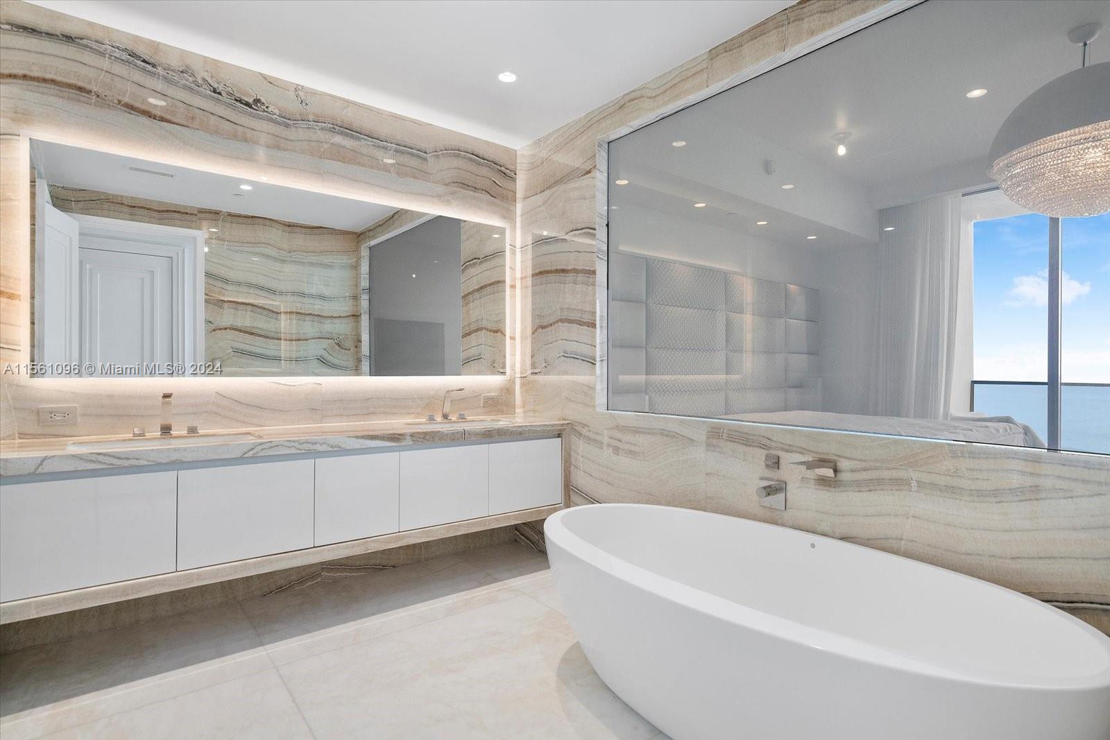 17901 Collins Avenue, Unit 902 Sunny Isles Beach, FL 33160 - Photo 26 of 47 a bathroom with a bathtub a double vanity sink and mirror