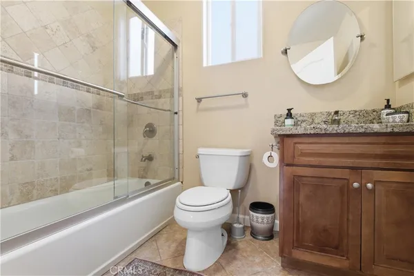 a bathroom with a granite countertop toilet sink and mirror