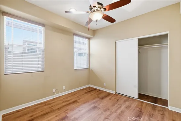 a view of an empty room with window and wooden floor