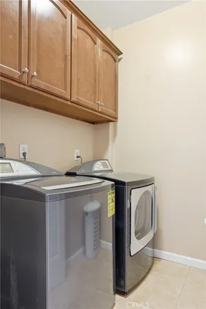 a utility room with stainless steel appliances granite countertop a sink and cabinets