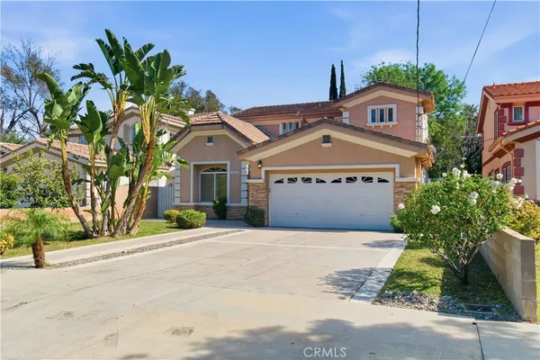 a front view of a house with a yard and a garage