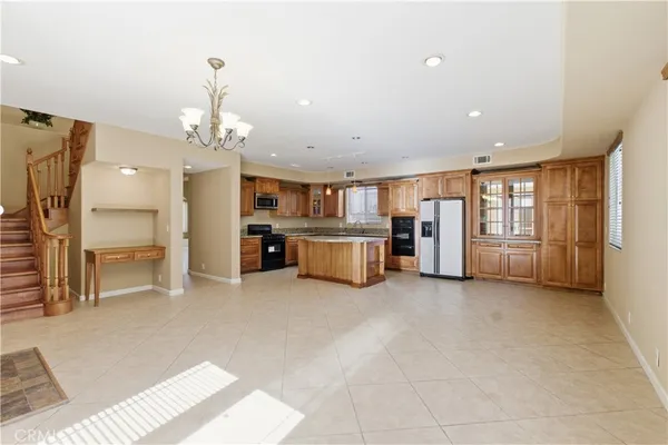 a big room with chandelier and kitchen view