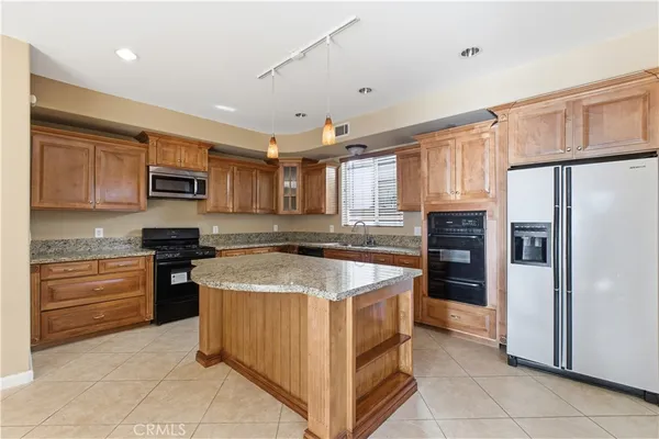 a kitchen with stainless steel appliances granite countertop a refrigerator stove and sink