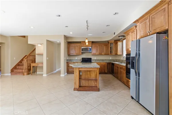 a kitchen with stainless steel appliances kitchen island granite countertop a refrigerator a stove a sink and a microwave