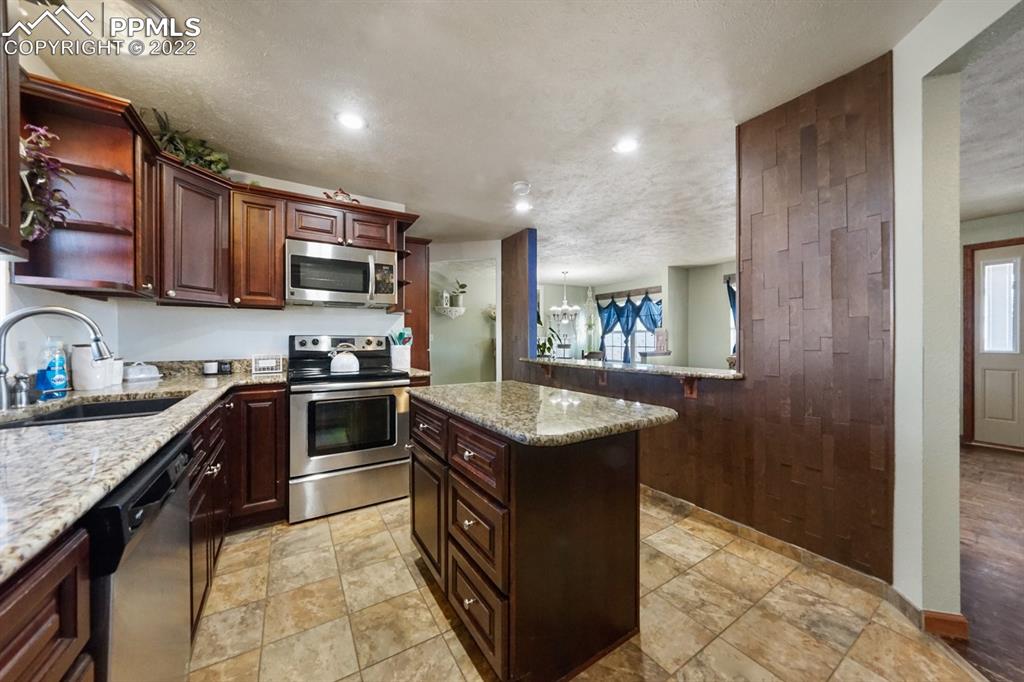 6260 Night Train Lane Yoder, CO 80864 - Photo 17 of 24 a kitchen with granite countertop a sink and a stove top oven