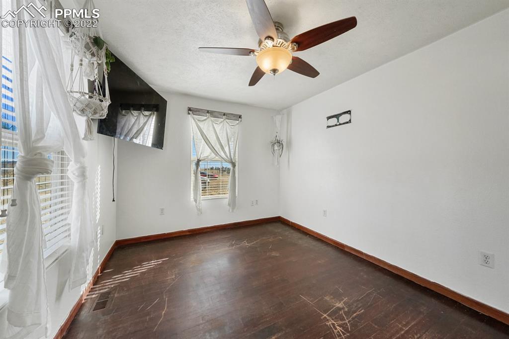 6260 Night Train Lane Yoder, CO 80864 - Photo 20 of 24 an empty room with wooden floor and windows