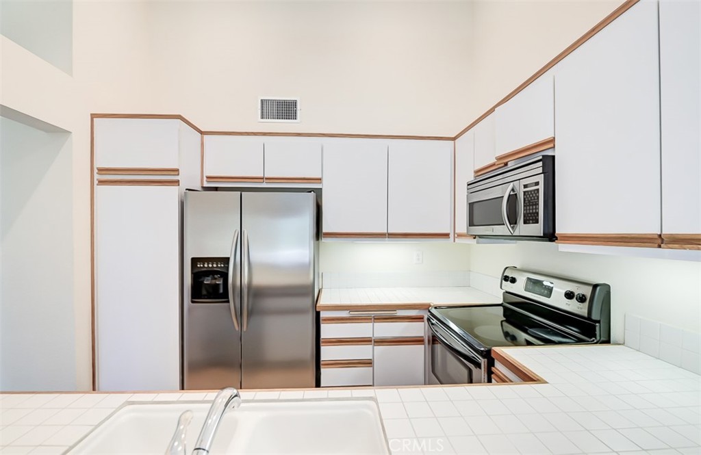 45 Campton Place Laguna Niguel, CA 92677 - Photo 15 of 22 a kitchen with stainless steel appliances granite countertop a refrigerator a stove and a sink with wooden floor