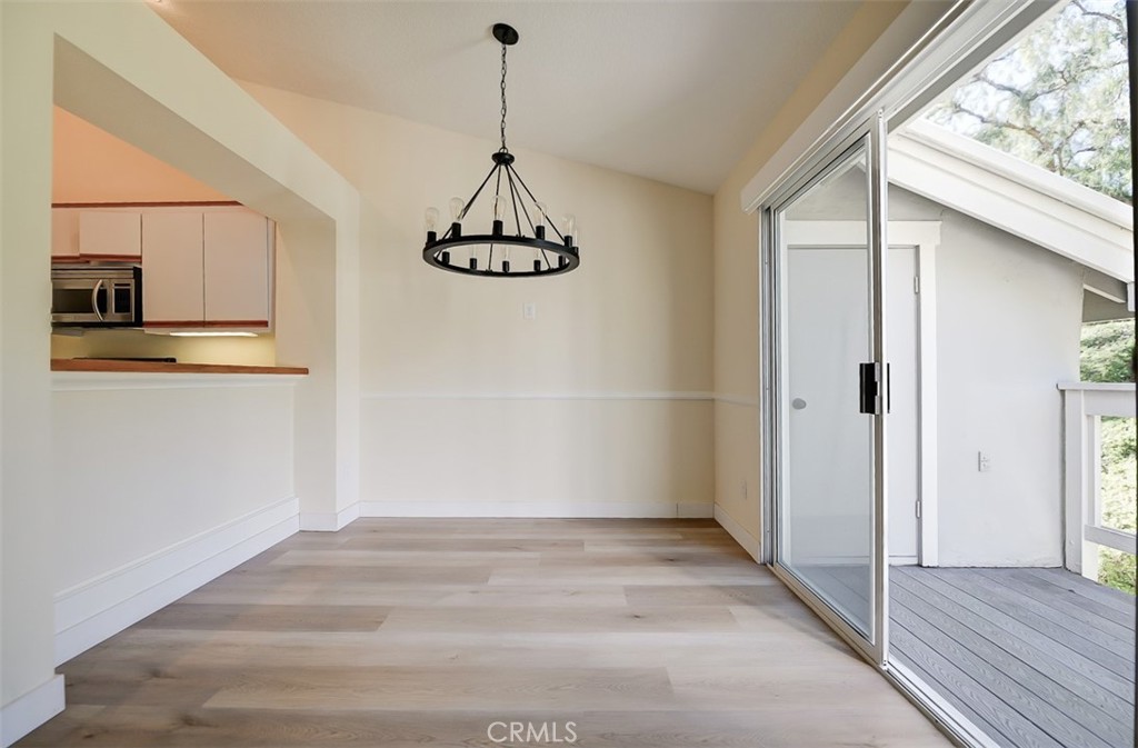 45 Campton Place Laguna Niguel, CA 92677 - Photo 7 of 22 a view of a hallway with wooden floor and chandelier