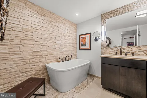 a bathroom with a sink mirror vanity and bathtub