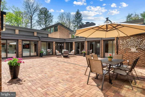 a view of a patio with a dining table and chairs with wooden floor and fence