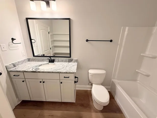 a bathroom with a granite countertop sink toilet and shower