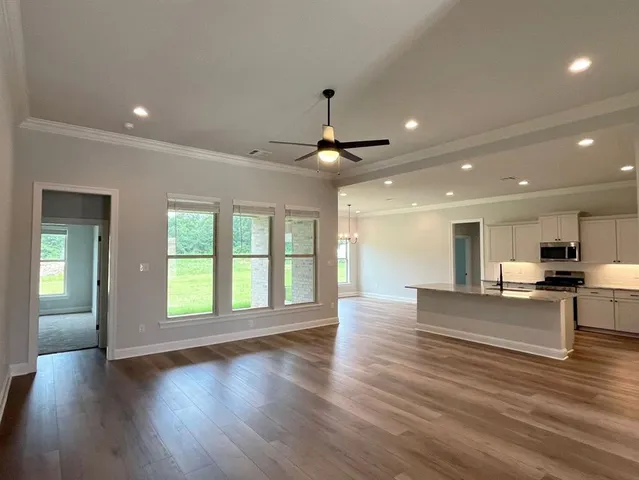 wooden floor in an empty room with a kitchen