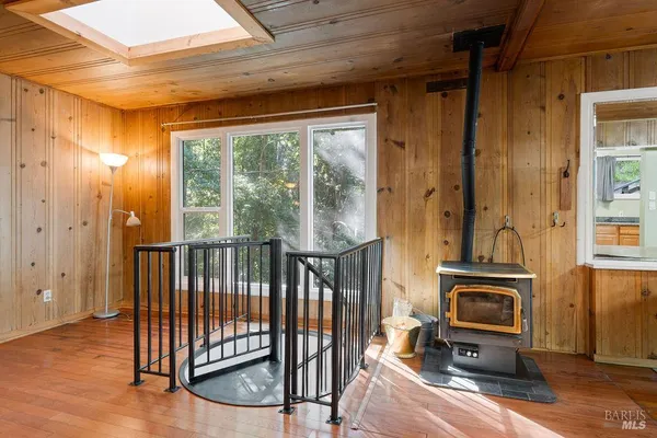 a view of a hallway with wooden floor and windows