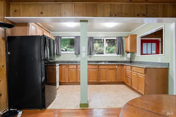 a kitchen with granite countertop stainless steel appliances a sink stove and cabinets