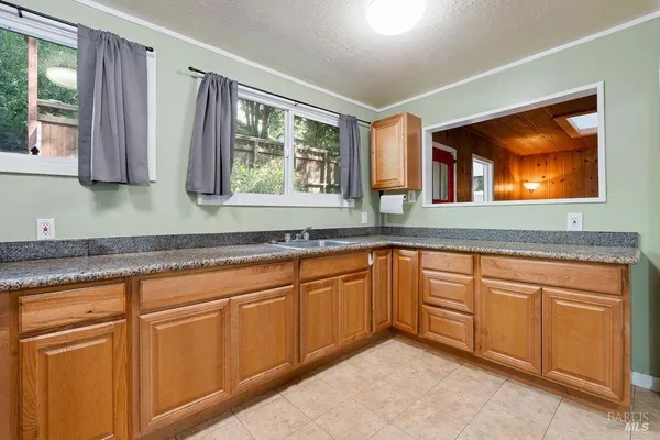 a kitchen with granite countertop a stove a sink and a granite counter top