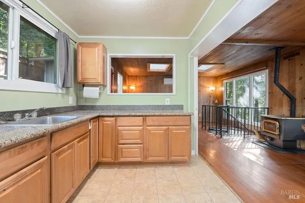 a kitchen with stainless steel appliances kitchen island granite countertop a refrigerator and a sink